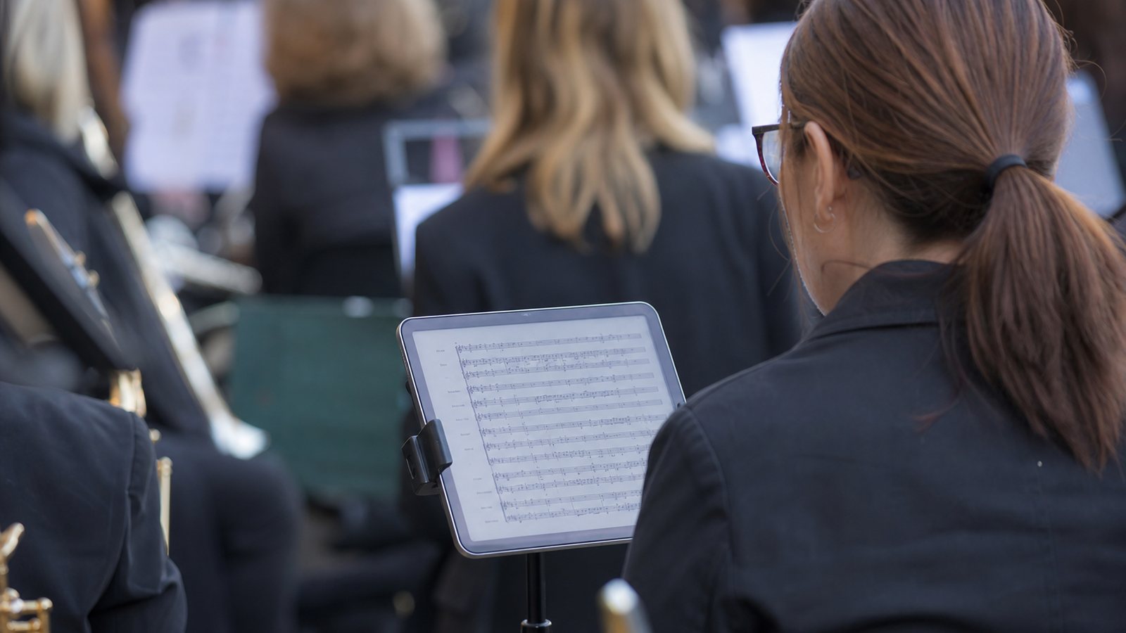 Choriste lisant sa partition sur une tablette pendant une répétition d'ensemble